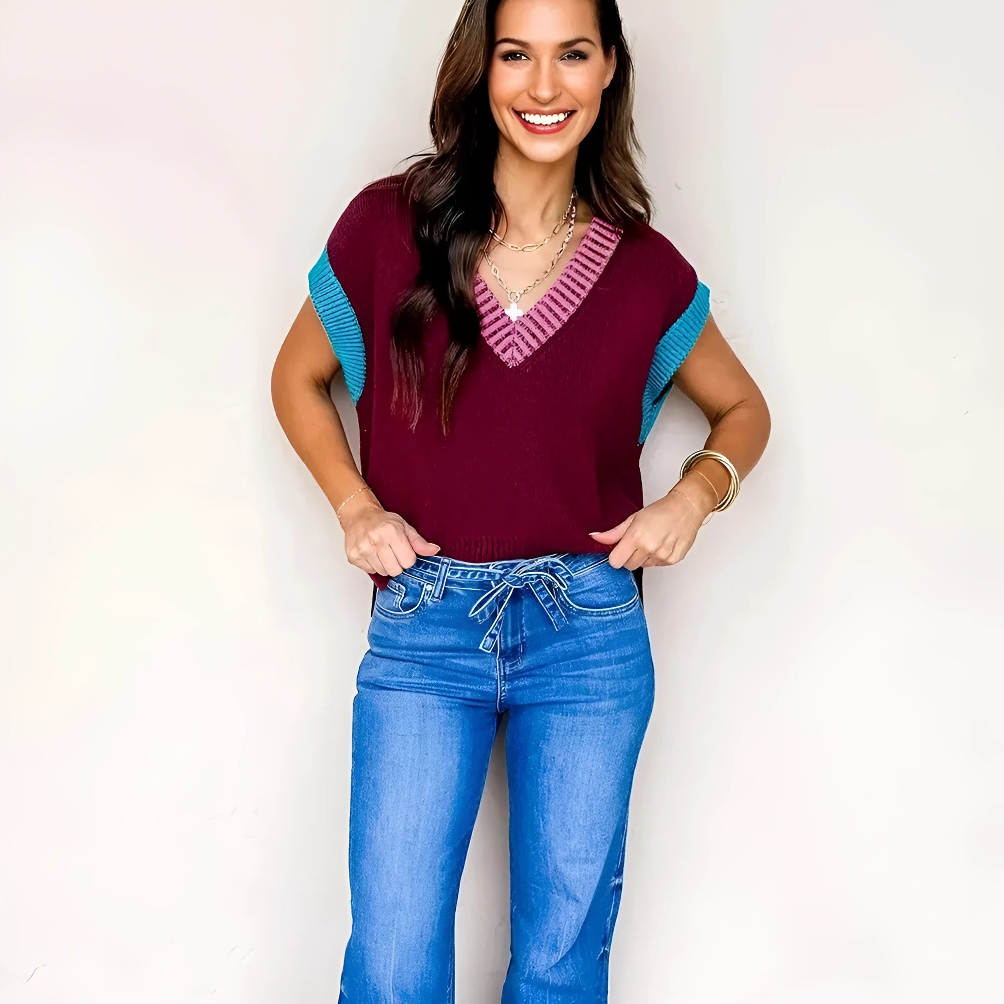 Burgundy loose V-neck sweater with short cuffed sleeves and contrast trim detail.
