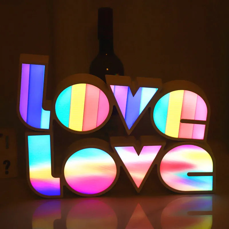 Rainbow-coloured plastic LED light spelling LOVE, standing 35.5cm tall on a table.