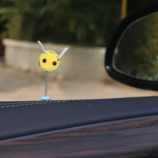 Soft fur bee car decoration on a swing spring for dashboard personalisation.