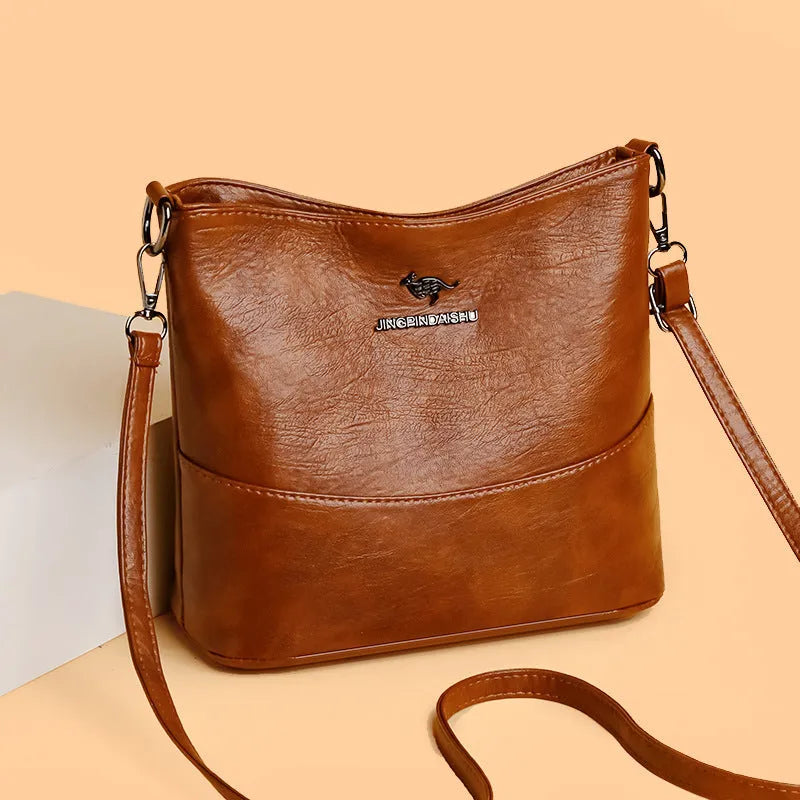 Women's black soft leather bucket-style shoulder bag with minimalist design and visible stitching