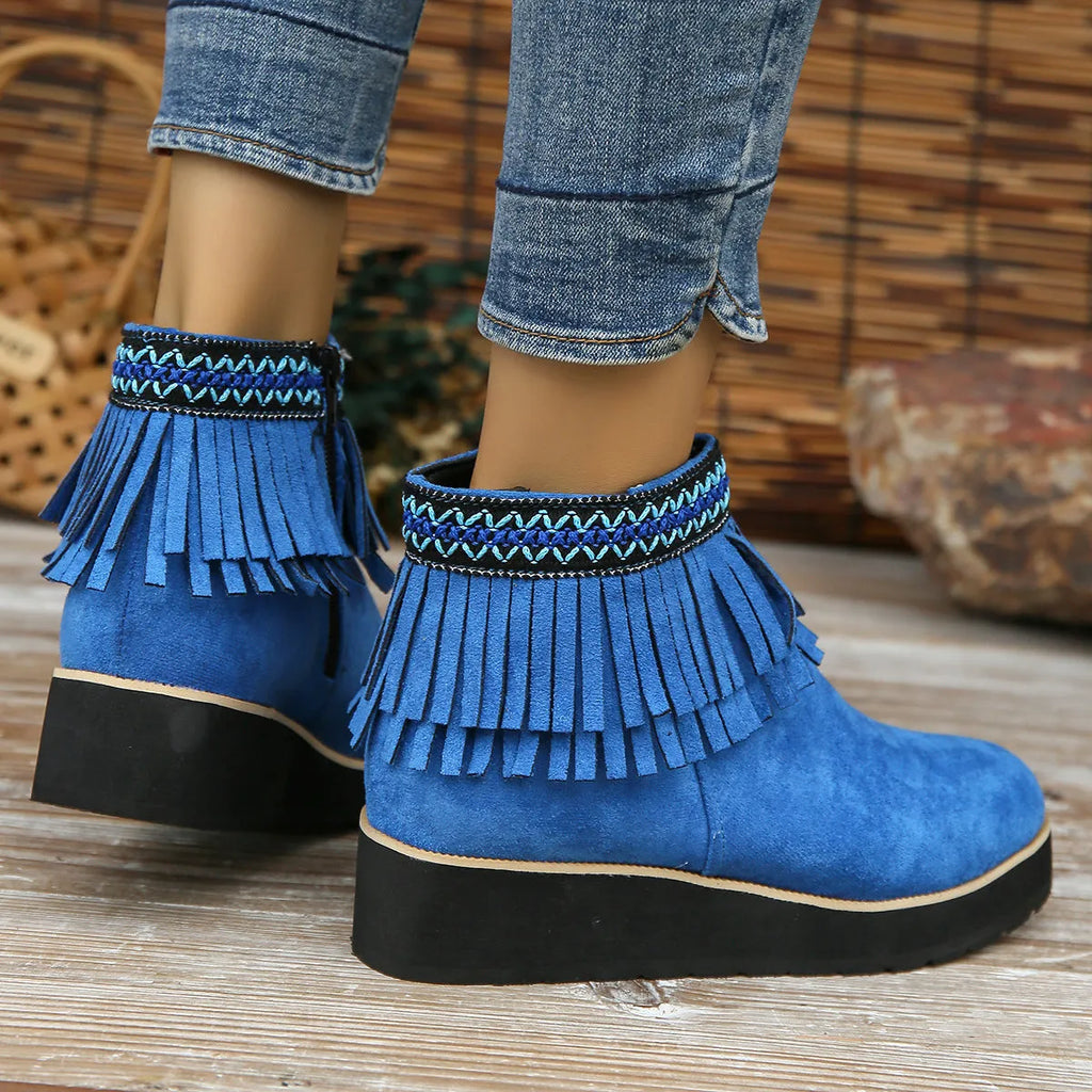 Women's black suede ankle boot with wedge heel, platform sole, side zip, and tassel detail.