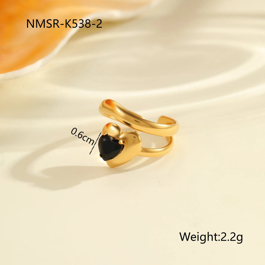 Geometric open mouth titanium steel ring for women with inlaid zircon stones on a grey background.