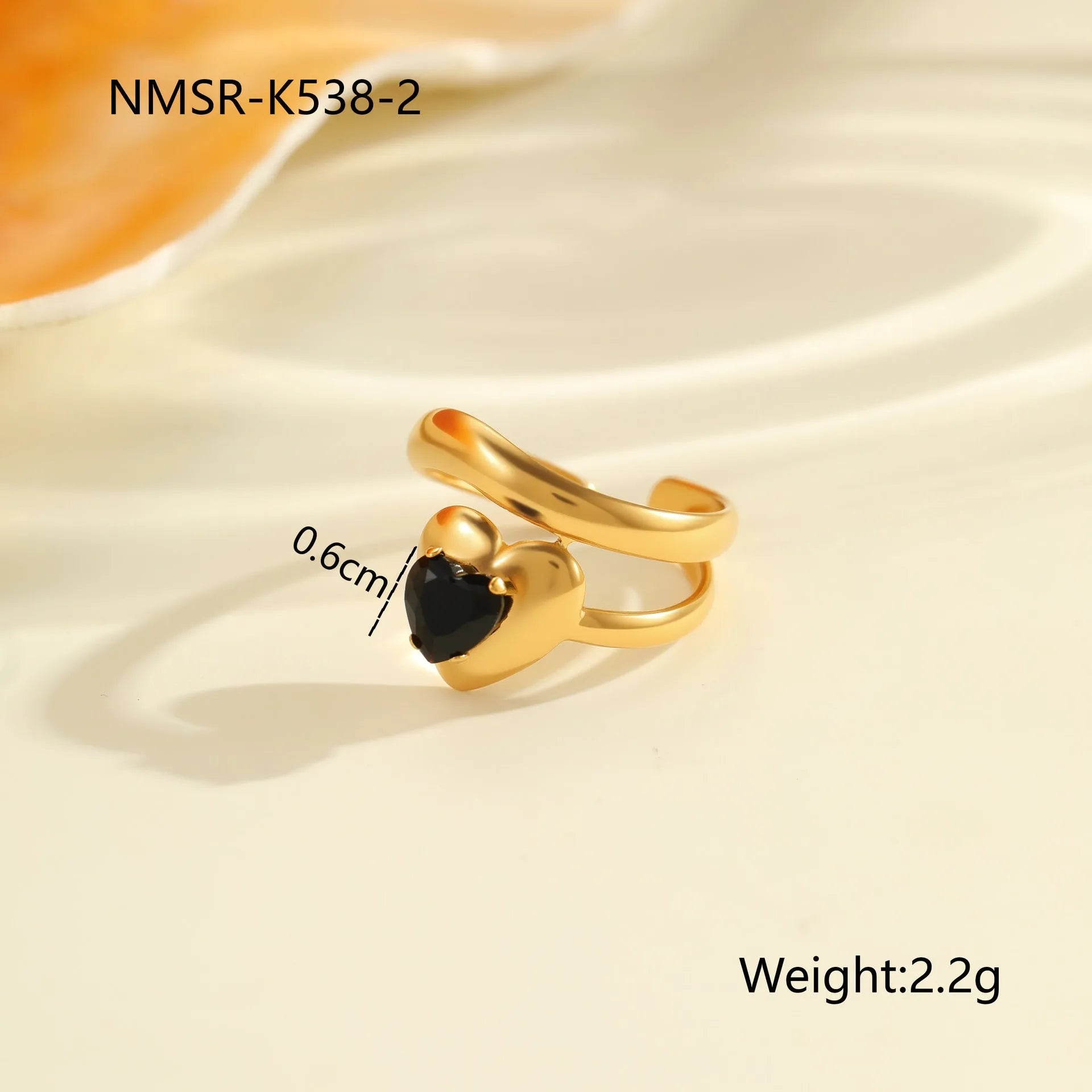 Geometric open mouth titanium steel ring for women with inlaid zircon stones on a grey background.