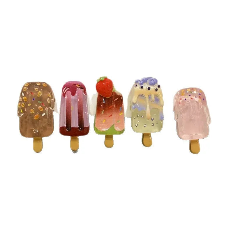 Close-up of a resin hair clip with a colourful cartoon ice cream design, shown in beige.
