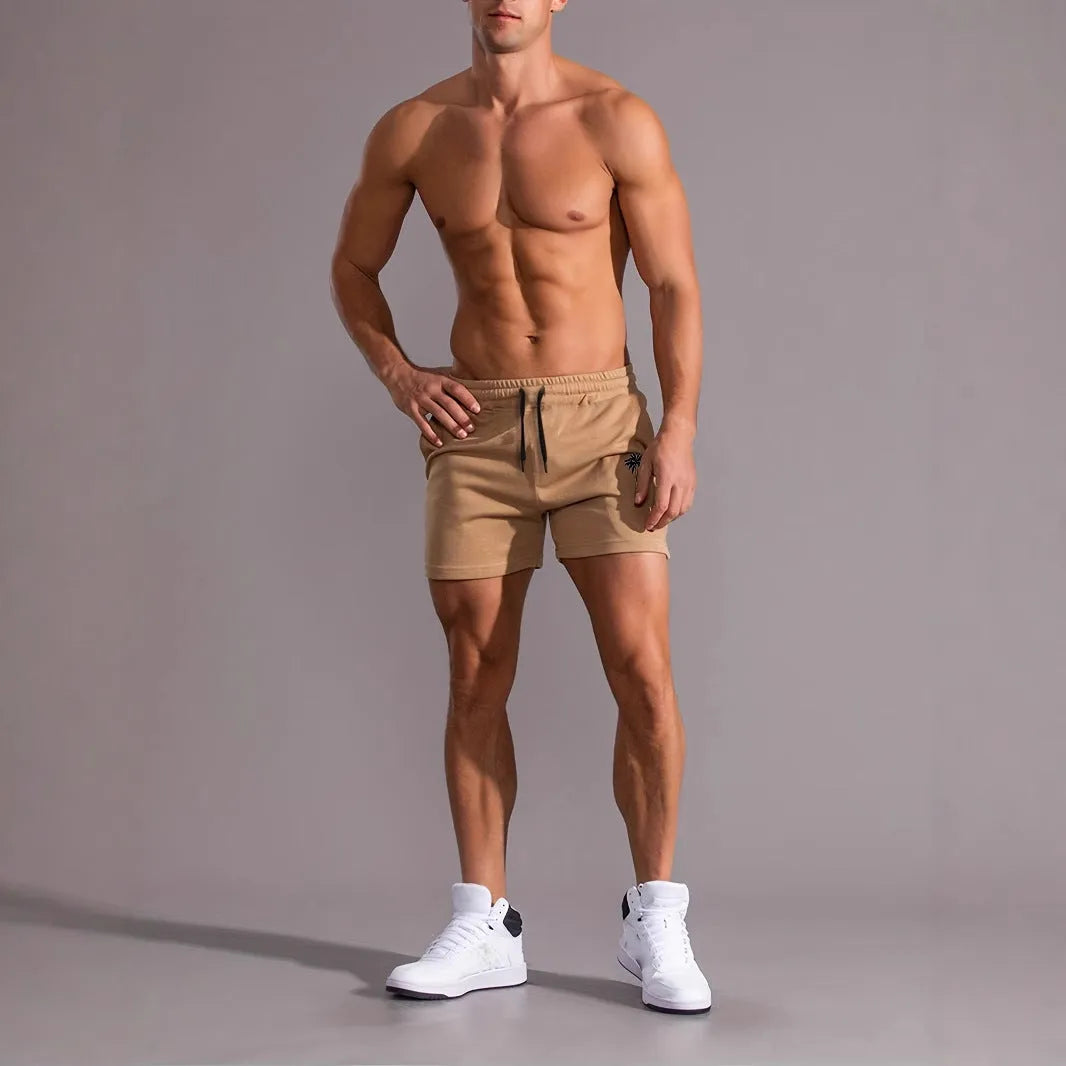 Men's khaki sports shorts with a coconut leaf print, showing straight-leg cut.