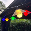 Outdoor LED string lights with flower-shaped bulbs hanging in a garden, showing warm white and coloured options.