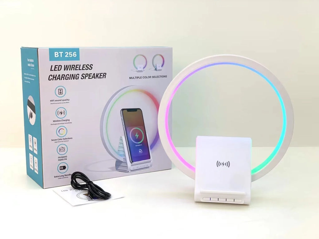 White smart Bluetooth speaker with ambient light and 15W wireless charging pad on desk