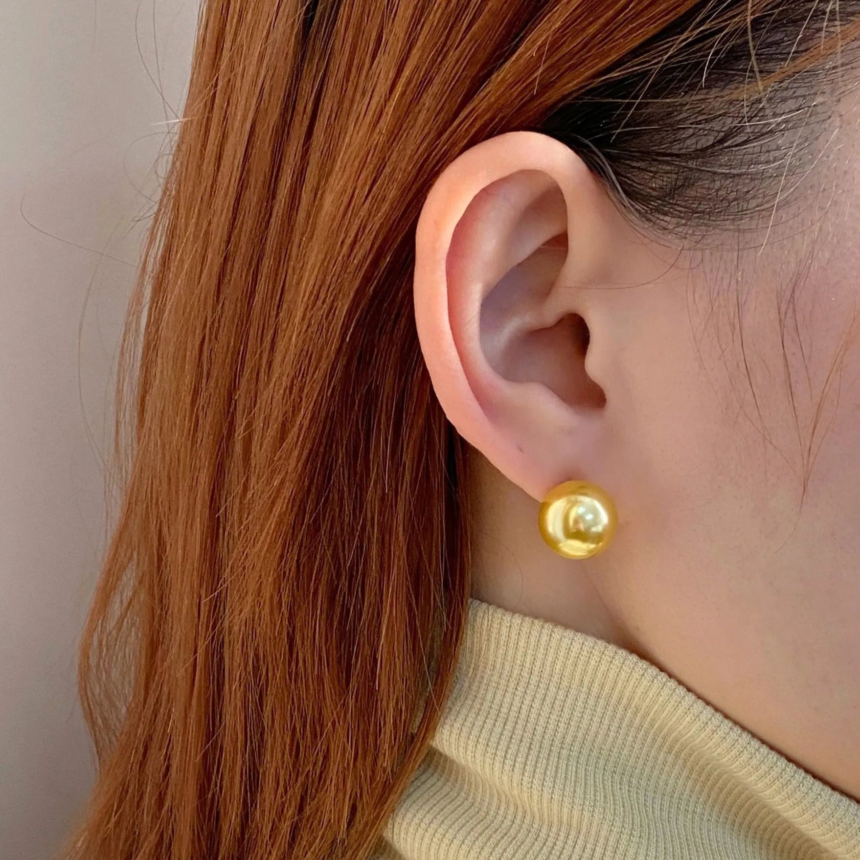 A pair of large pearl stud earrings with an eight-point star geometric setting in silver.
