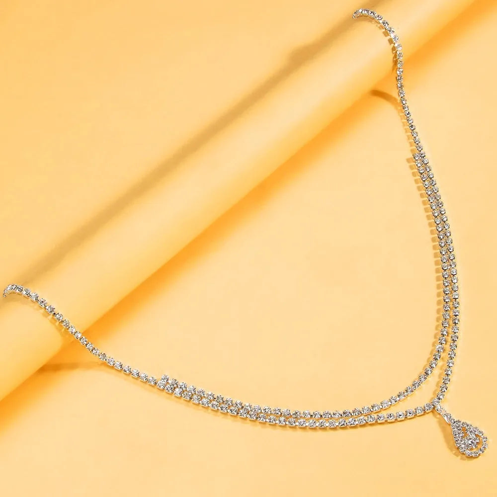 Gold or silver waist chain with a water drop rhinestone pendant and lobster buckle.