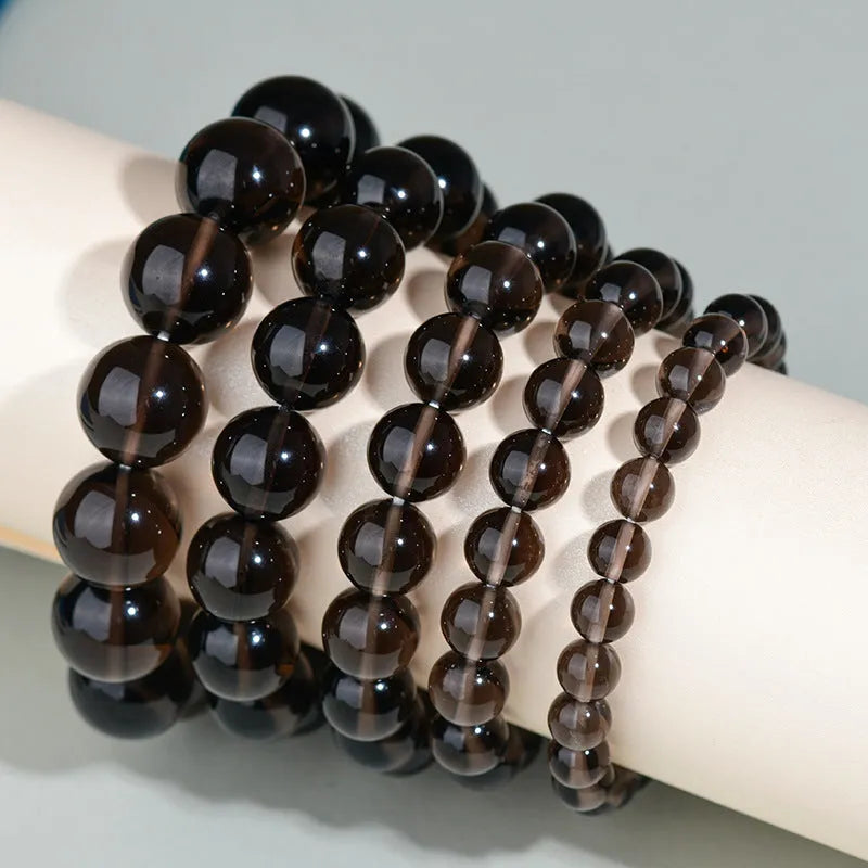 Hand-woven round obsidian bead bracelet for couples, showing colour options on a wrist.