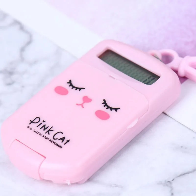 Creative cookie-shaped cute mini plastic calculator in black with key ring on a desk