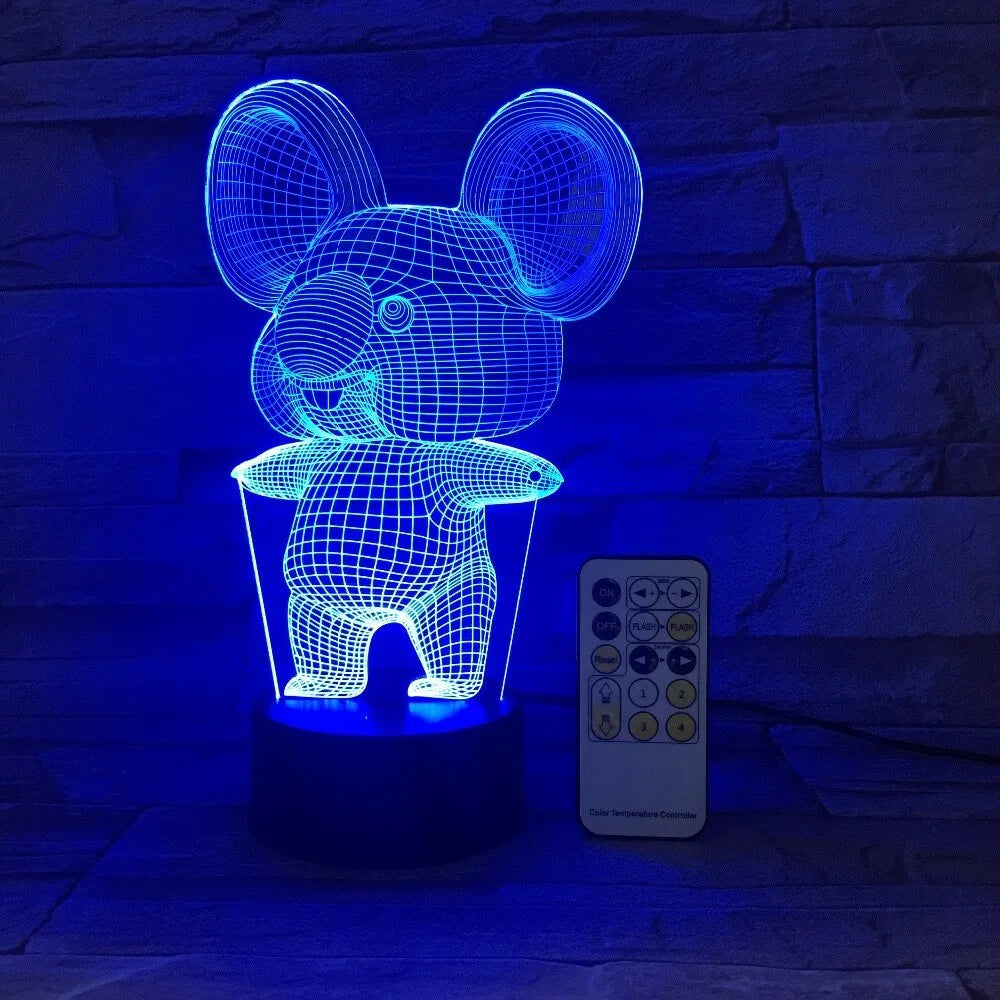 Black koala-shaped LED night light with remote control on a table, showing multi-colour illumination.