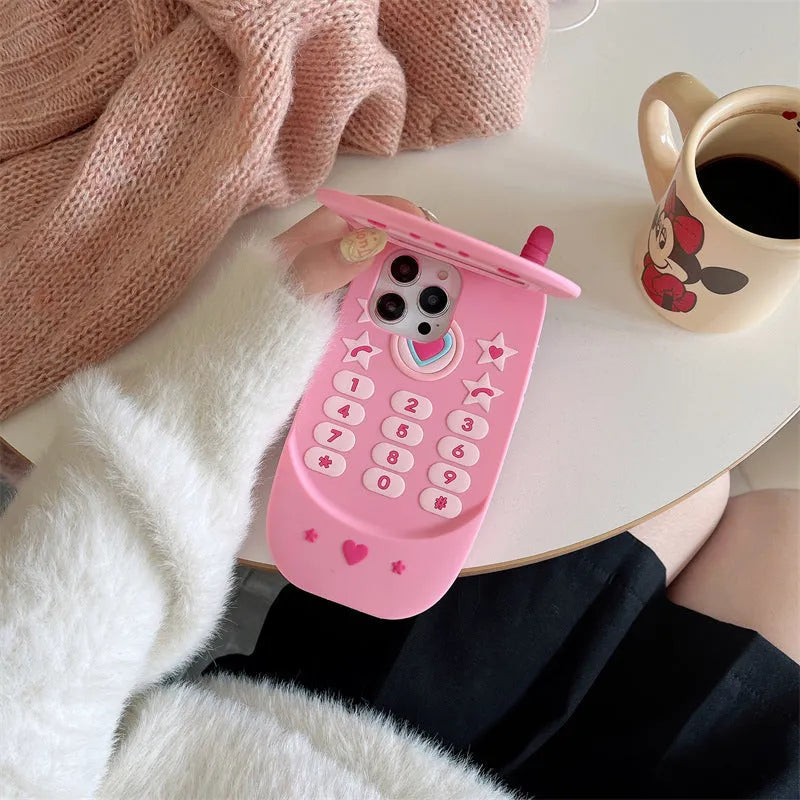 Pink silicone iPhone case shaped like a flip phone with a front mirror.