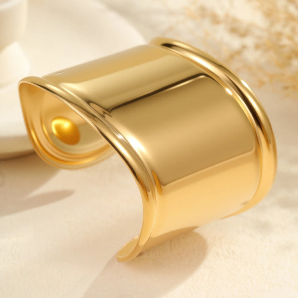 Women's exaggerated wide stainless steel bracelet with 18K gold plating and wave geometric design.