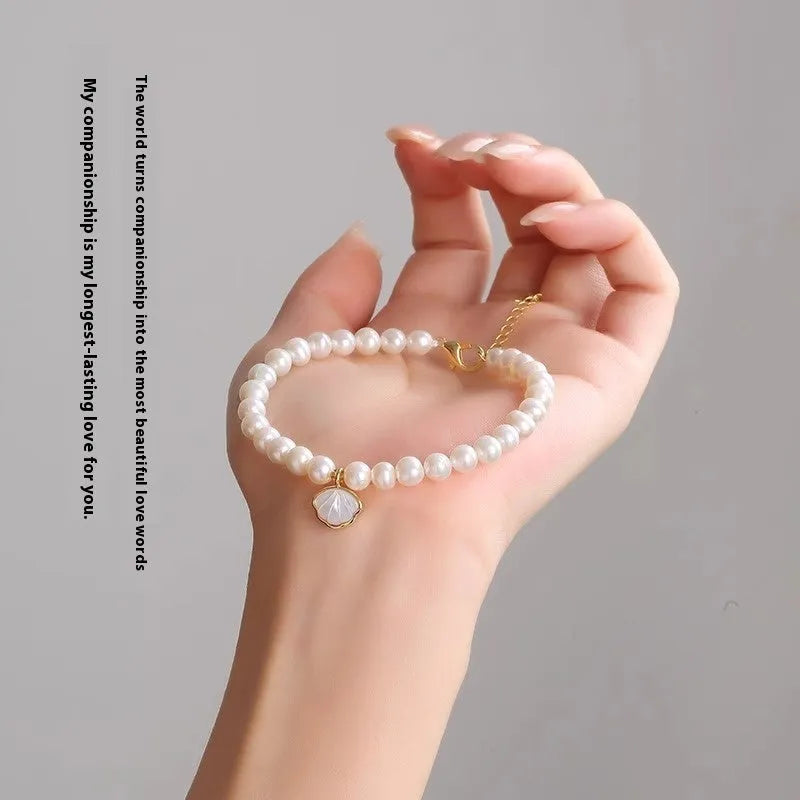 Women's freshwater pearl bracelet with fan-shaped alloy shell and choice of elastic or chain closure