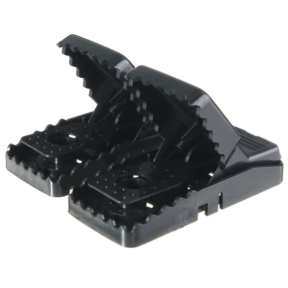Six black plastic snapping mousetraps with set triggers on a white background.