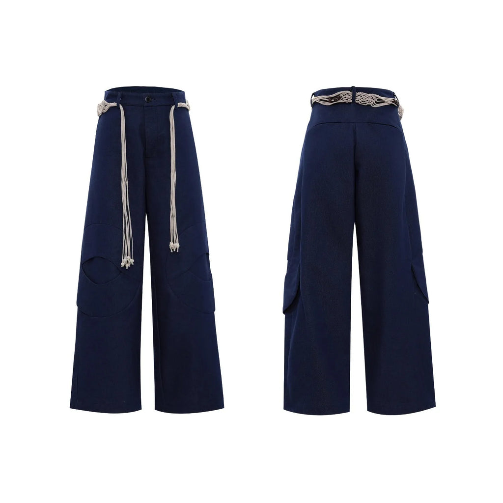 Men's dark blue straight-leg trousers with 3D cutting, zipper decorations, and a tassel pocket detail on a micro-elastic cotton fabric.