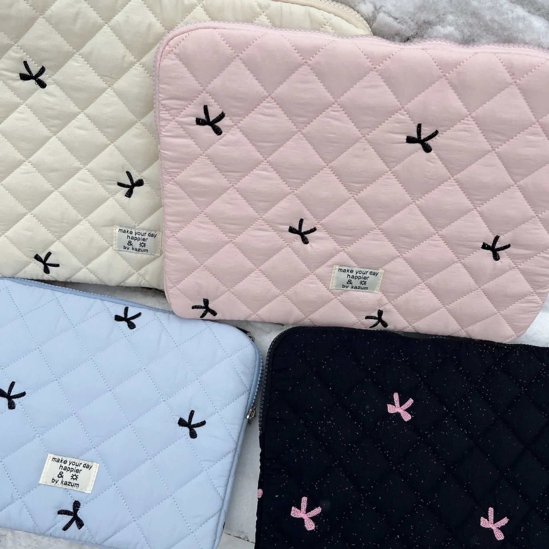 Nylon laptop storage bag with embroidered rhombus and bow design in light blue.