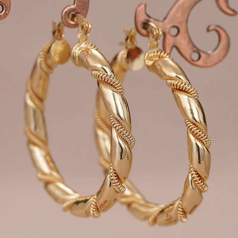 Golden geometric ear clip earrings with ring and line design elements made from copper