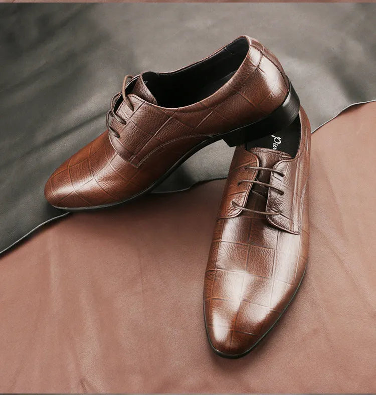 Men's black leather derby shoes with a pointed toe and rubber sole on a neutral background.