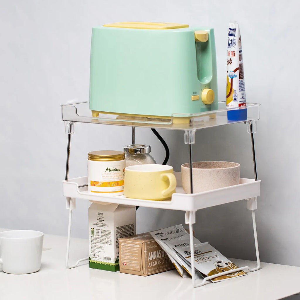 A transparent and a white plastic kitchen supplies rack for desktop or cupboard organisation.