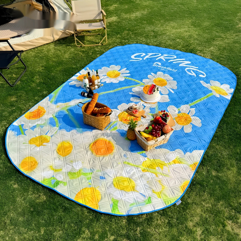 Large rectangular waterproof picnic mat in a seasonal colour, laid out on grass, showing its brushed fabric texture.