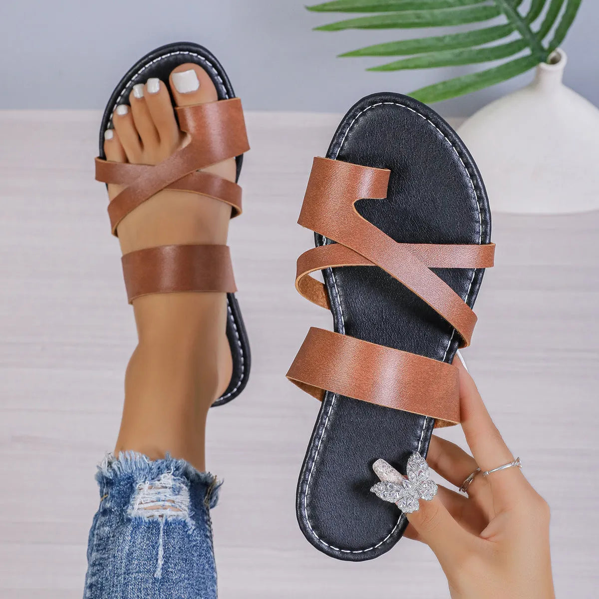 Casual beach slipper in black with round head, one-line design, and hollow-out pattern on artificial PU upper.