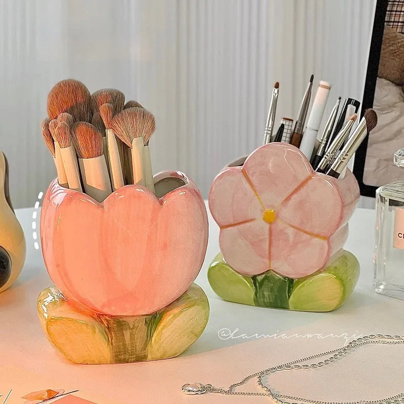 Ceramic pen holder storage box with floral decoration on desk.