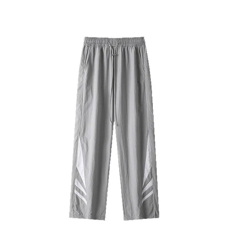 Man wearing straight leg grey casual trousers, showing the loose fit and mid-rise waist.
