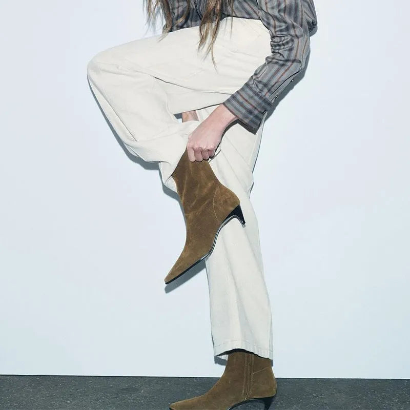 Brown square toe women's boots with a side zipper and a mid stiletto heel on a wooden floor.