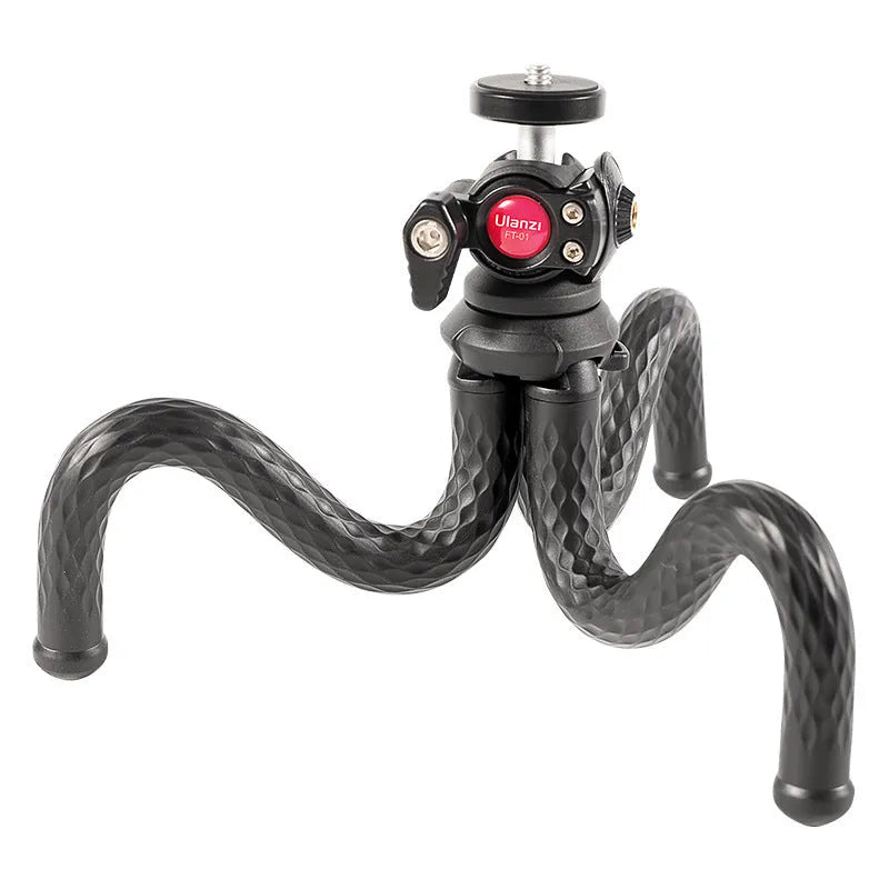 Black octopus-style flexible tripod with mobile phone clip extended on a table.