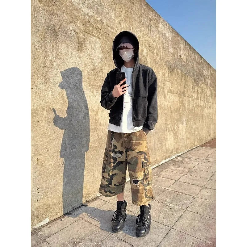 Men's loose fit camouflage patch ripped cropped jeans in a straight leg style.