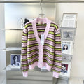 Pink wool knitted cardigan sweater on a hanger, showing round neck and cardigan style options.