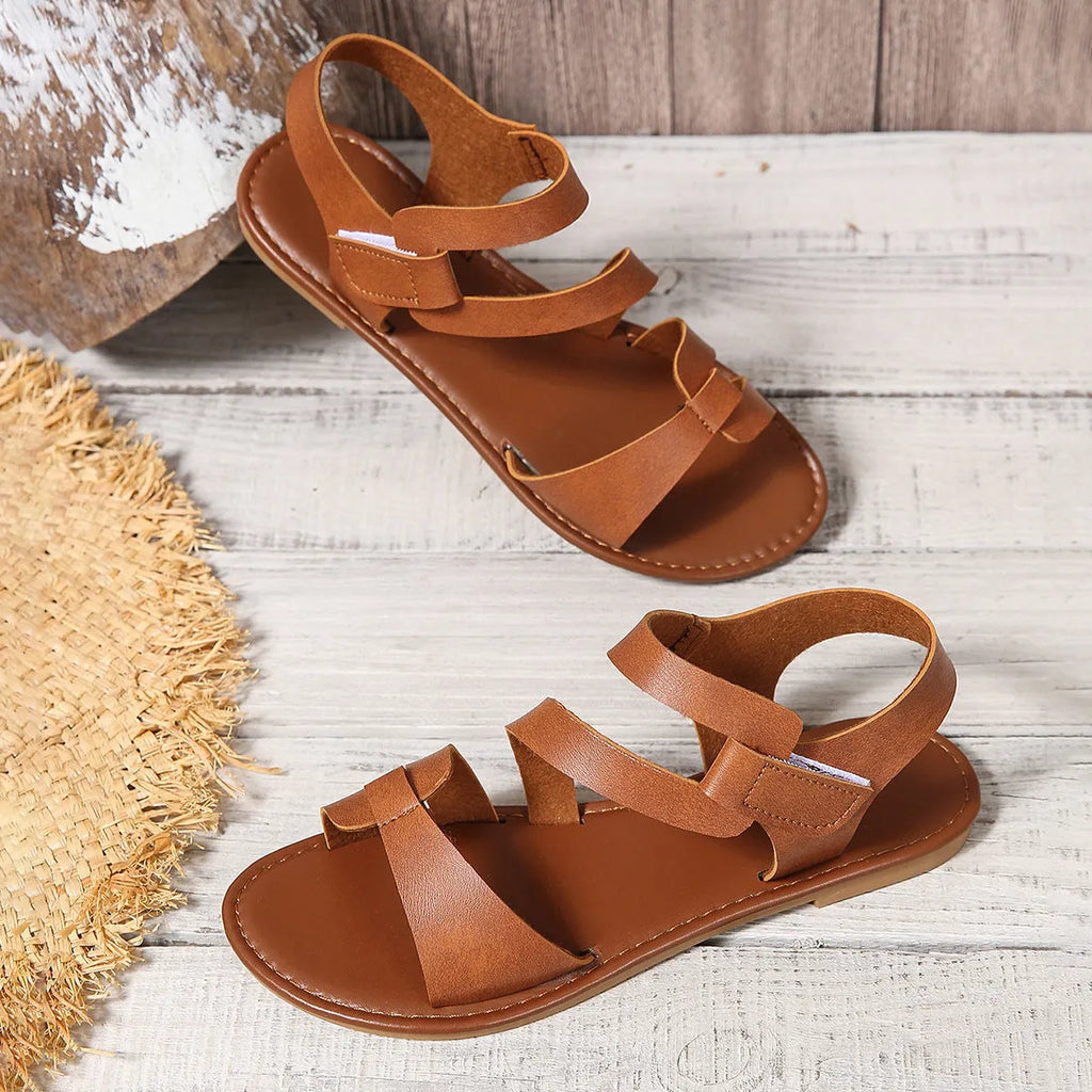 Women's flat sandals with velcro strap showing round toe design and rubber sole