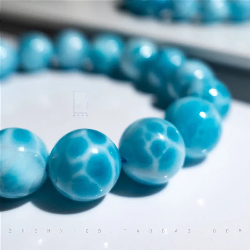Blue and natural toned bodhi bracelet with a sea-pattern crystal stone centre and pearl accent.