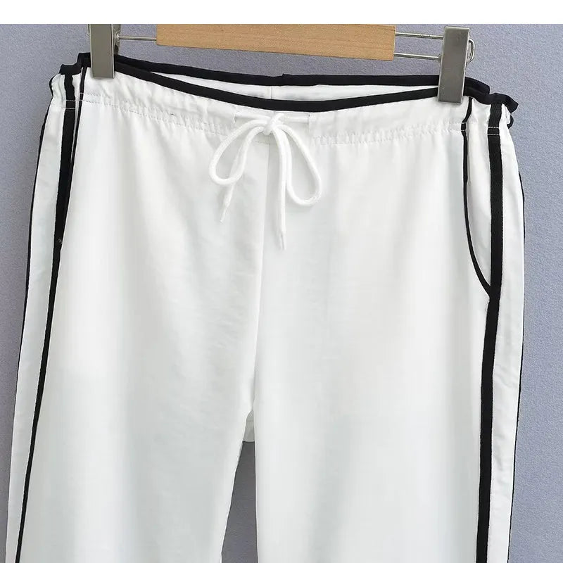 Navy blue loose straight-leg trousers with white parallel ribbon detail on the legs.