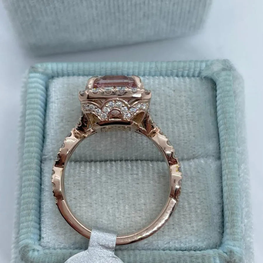 Geometric rose gold coloured alloy ring for women and men on a grey background.