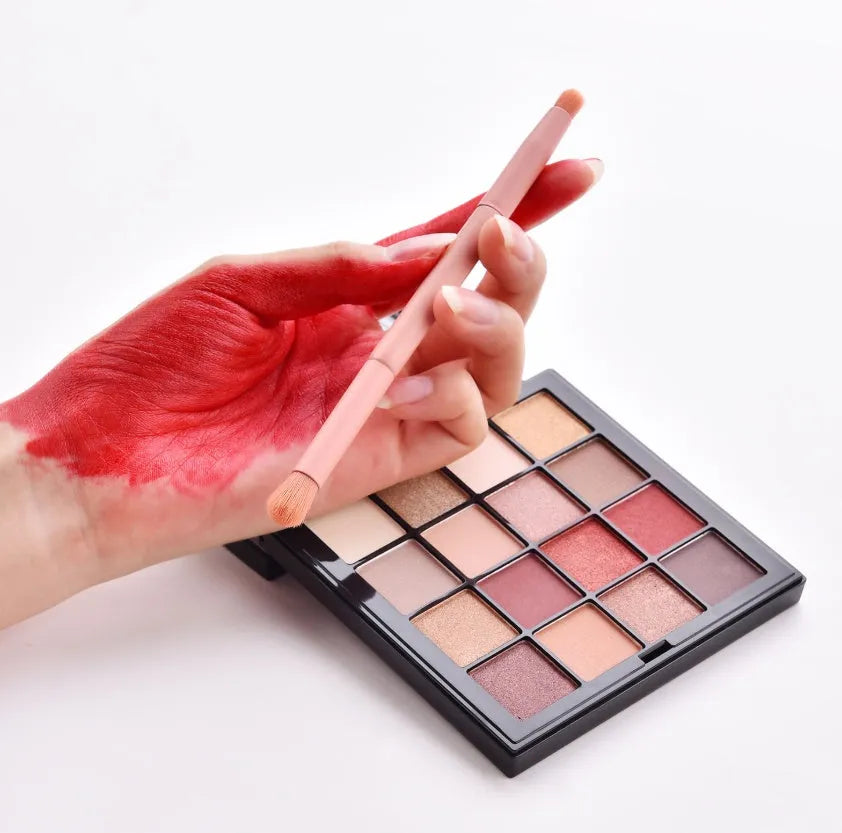 Ten professional makeup brushes with wooden handles in a pink box, including powder, foundation, and double-ended brushes.