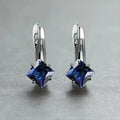 A pair of women's diamond-shaped copper earrings with inlaid zircon stones, shown in a blue colour variant.