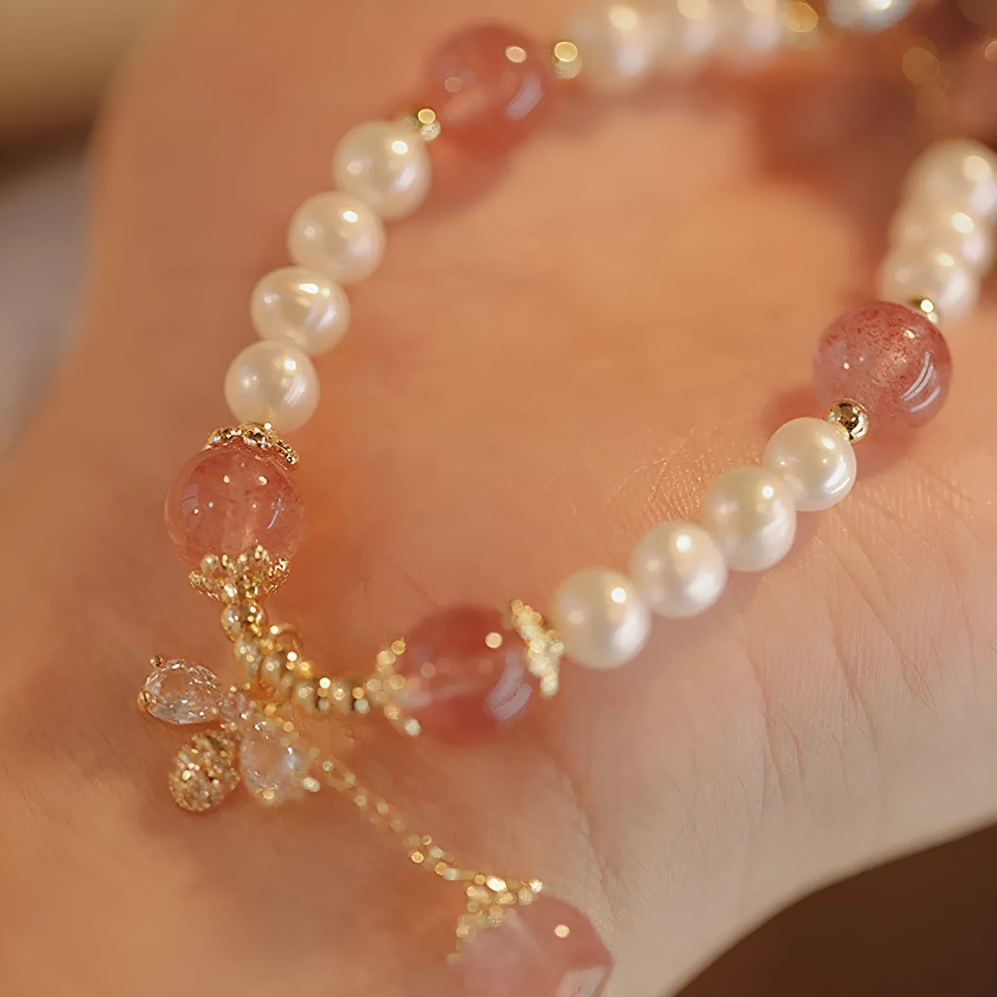 INS style women's crystal bracelet with strawberry quartz stones and a central bow detail.