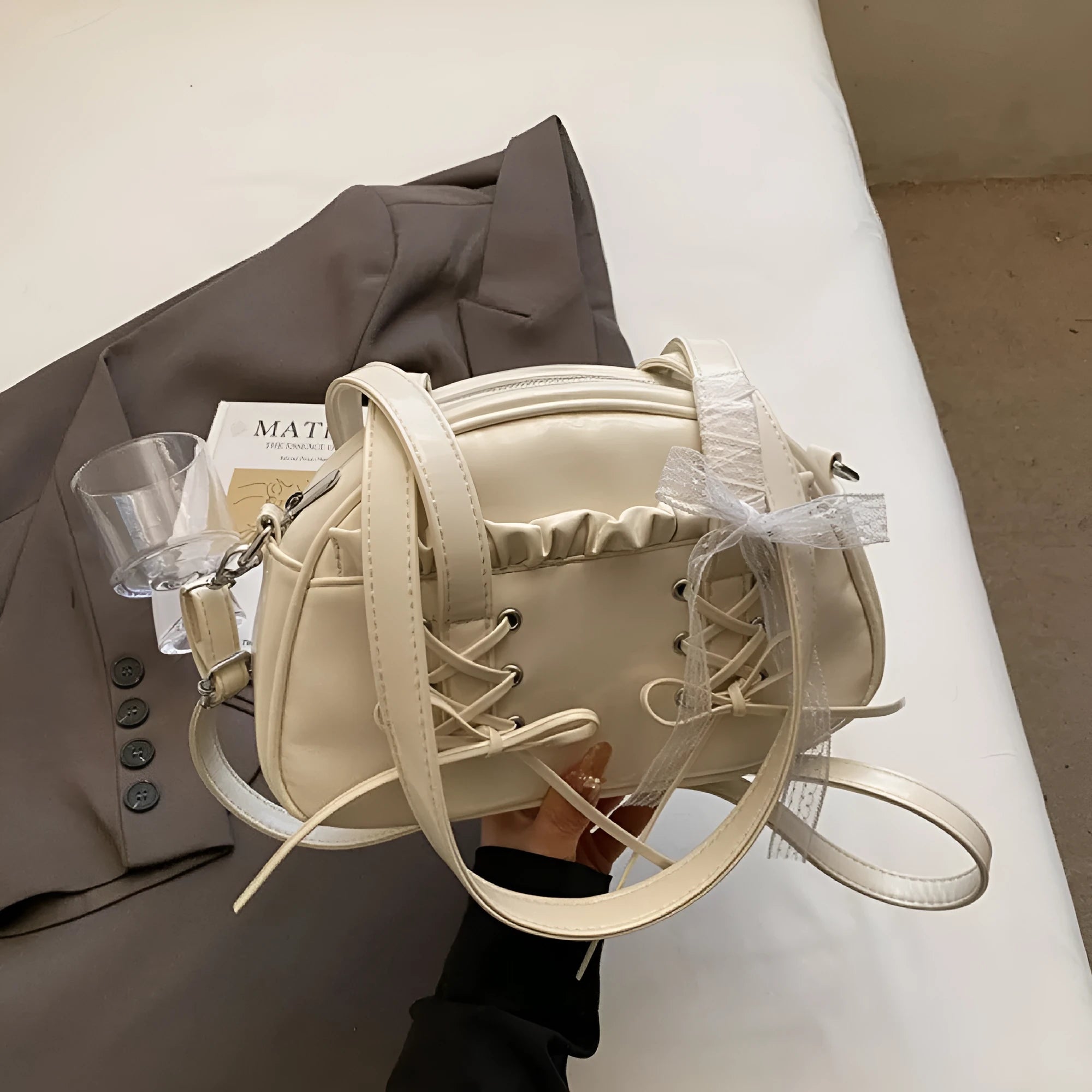 Women's fashion shoulder handbag with bandage bow design in PU leather showing interior phone pocket