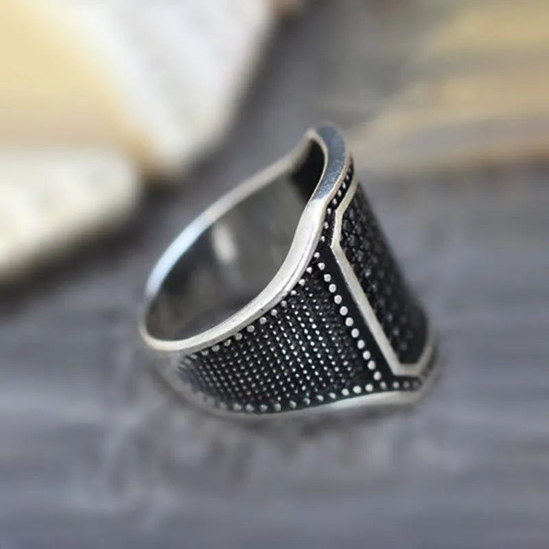 Black alloy ring with copper inlaid zircon detailing showing front view on neutral background
