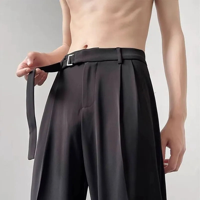 Men's black loose straight-leg trousers with a non-ironing finish on a hanger