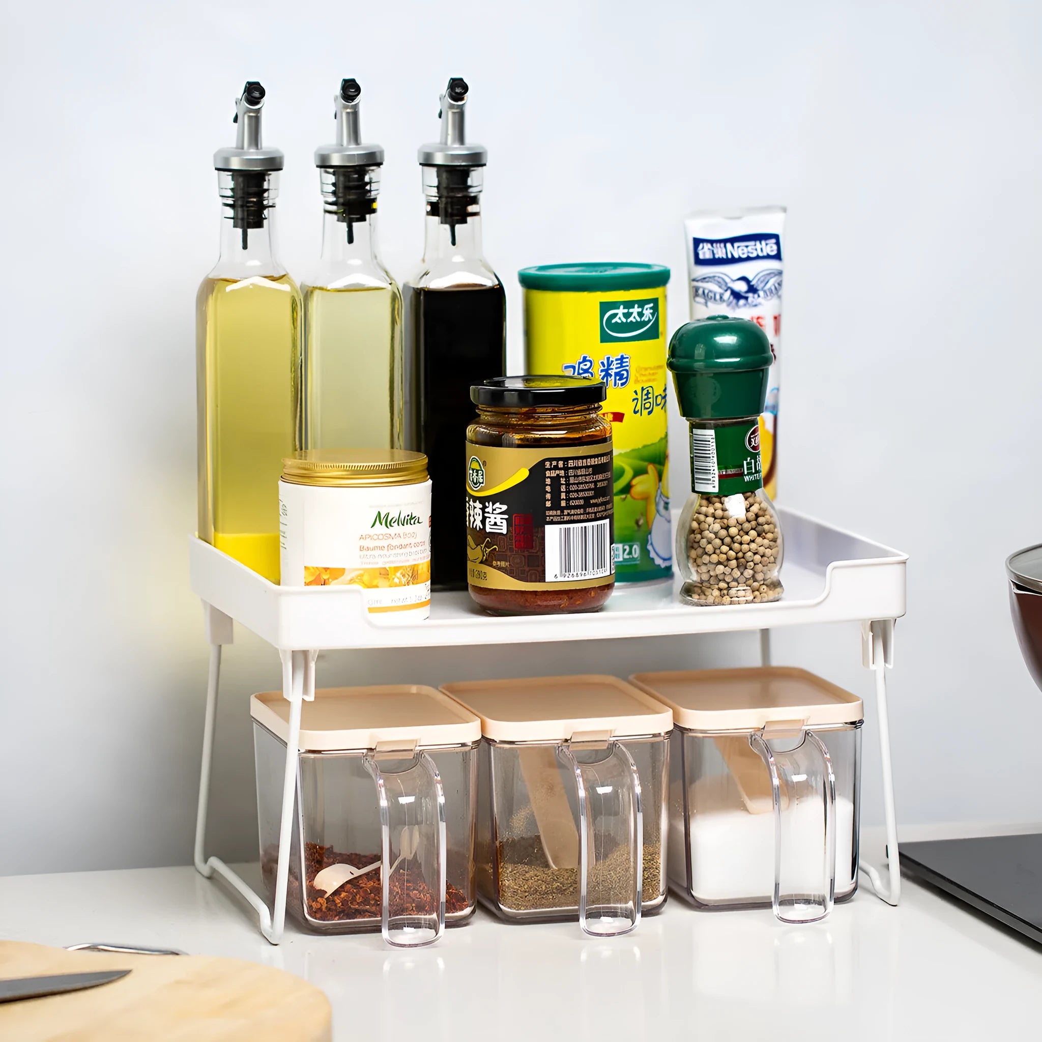 A transparent and a white plastic kitchen supplies rack for desktop or cupboard organisation.