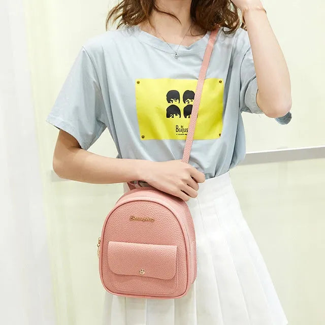 Small black PU shoulder backpack showing front zipper and dimensions