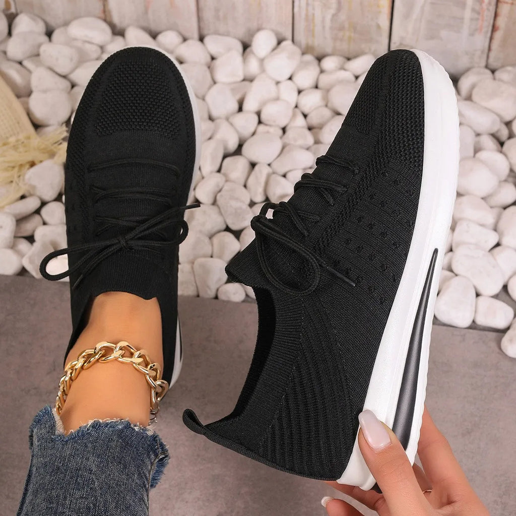 Women's red, black, and blue low-top casual sneakers with a round toe and lace-up front.