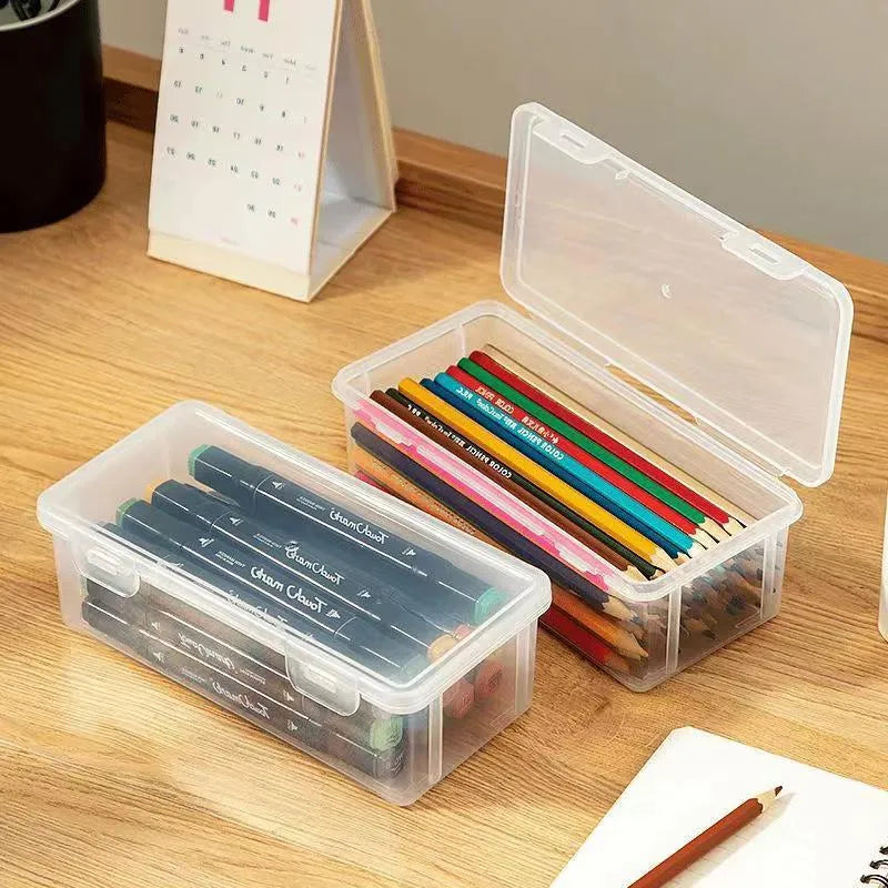 Transparent plastic storage box containing coloured pencils and drawing materials
