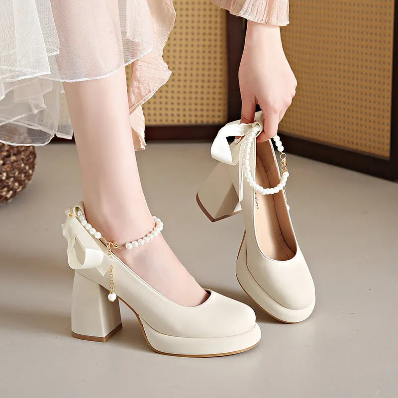 Beige women's Mary Jane shoes with a chunky heel and an ankle-strap buckle on a round toe.
