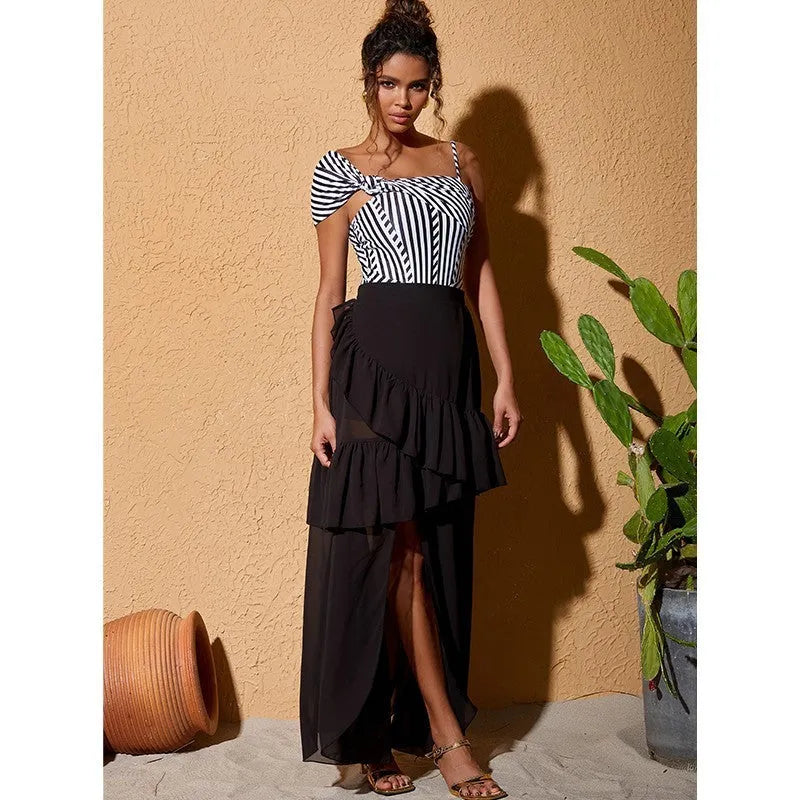 Women's striped one-piece swimsuit with a black ruffle skirt, shown on a mannequin.
