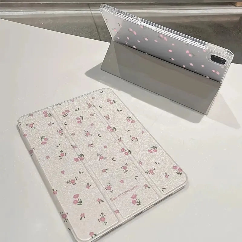 Transparent floral patterned tri-fold protective case for Apple iPad in stand position.